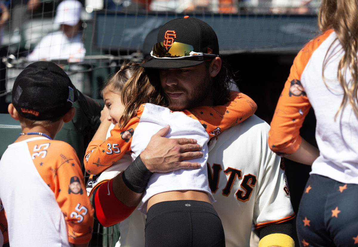 SF Giants shortstop Brandon Crawford hugs one of his children before his team takes on the Los Angeles Dodgers at Oracle Park on October 1, 2023.